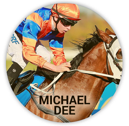 jockey in an orange and blue jacket rides a horse